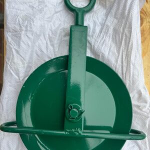 Brand new green scaffolding gin wheel pulley with eye bolt, guard bar, and heavy-duty steel construction laid flat for inspection