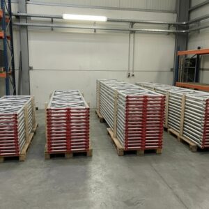 Stacked pallets of 1330mm HD Asterix Alloy Beams in warehouse – high-strength aluminum scaffold truss beams with red protective end caps, ready for delivery in 1m to 4m lengths