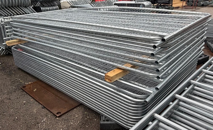Galvanised Heras temporary fencing panels stacked in the yard